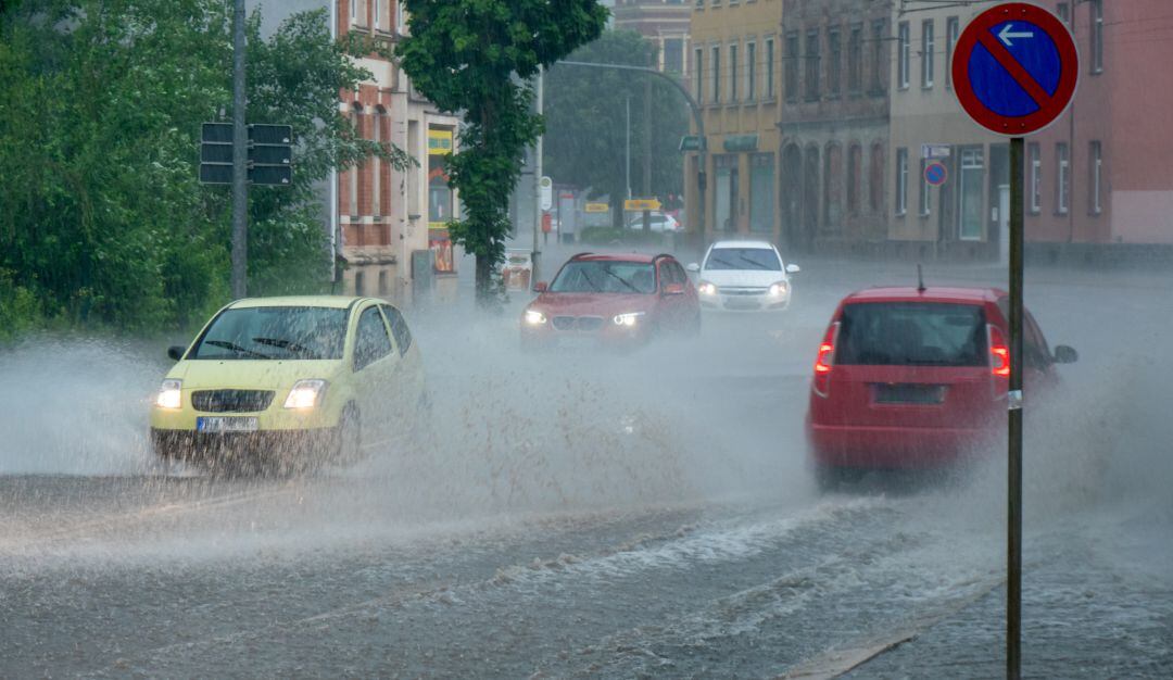 Varios coches circulan en un día lluvioso.