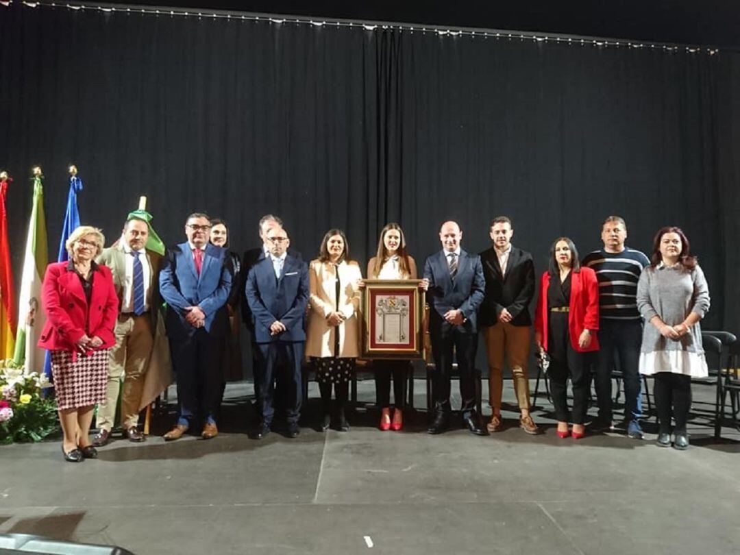 Foto de familia con todos los miembros de la corporación presentes, Gema Jiménez con el cuadro conmemorativo en el centro