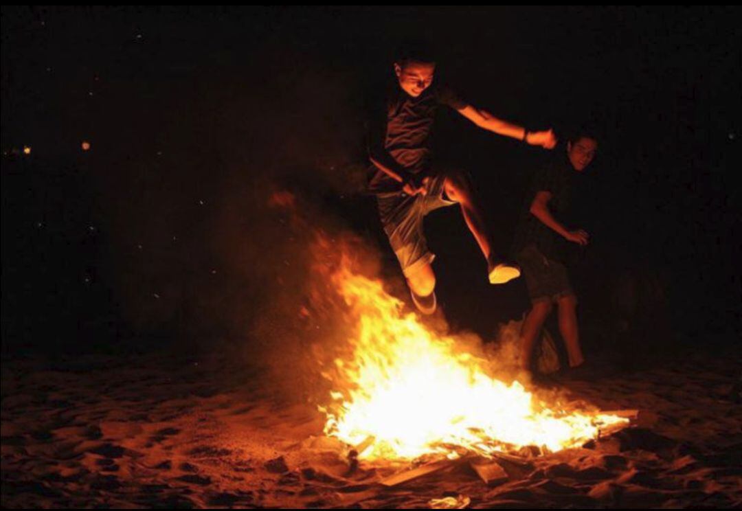 Joven saltando una hoguera en las playas de Castellón