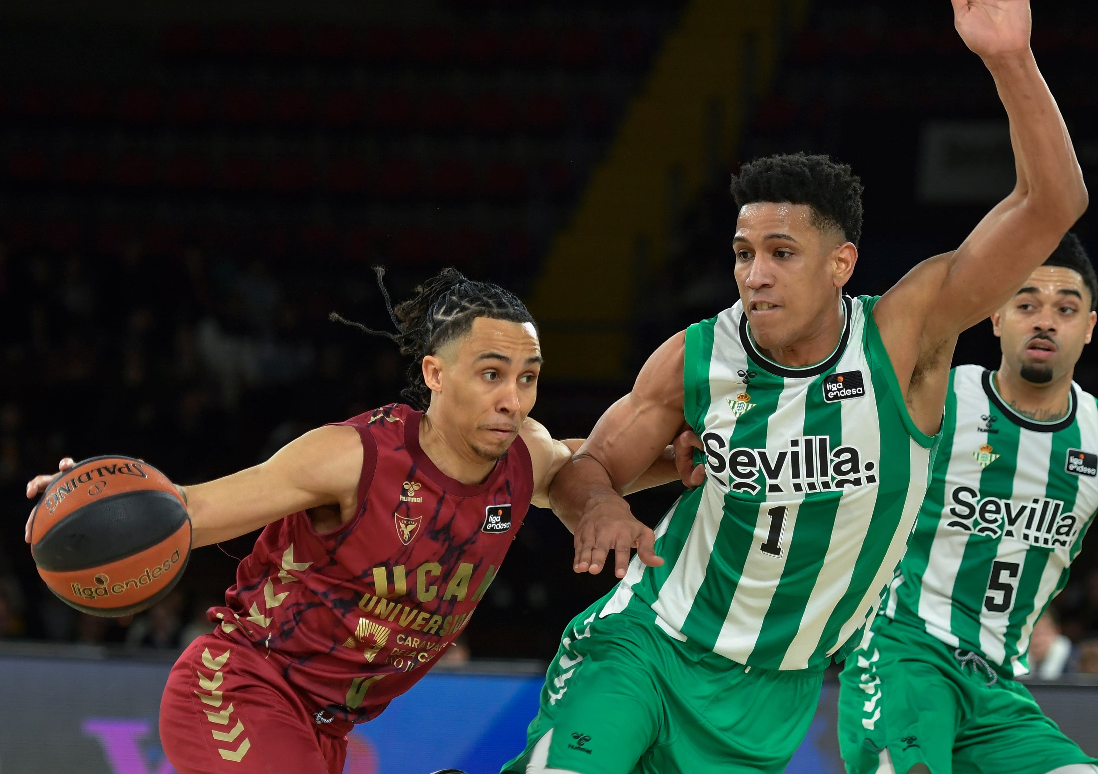 SEVILLA, 04/02/2023.- El ala-pívot del Real Betis Tyson Pérez (d) defiende el avance de Travis Trice, del UCAM Murcia, durante el partido de la Liga Endesa disputado este sábado en el pabellón de San Pablo, en Sevilla. EFE/ Raúl Caro.
