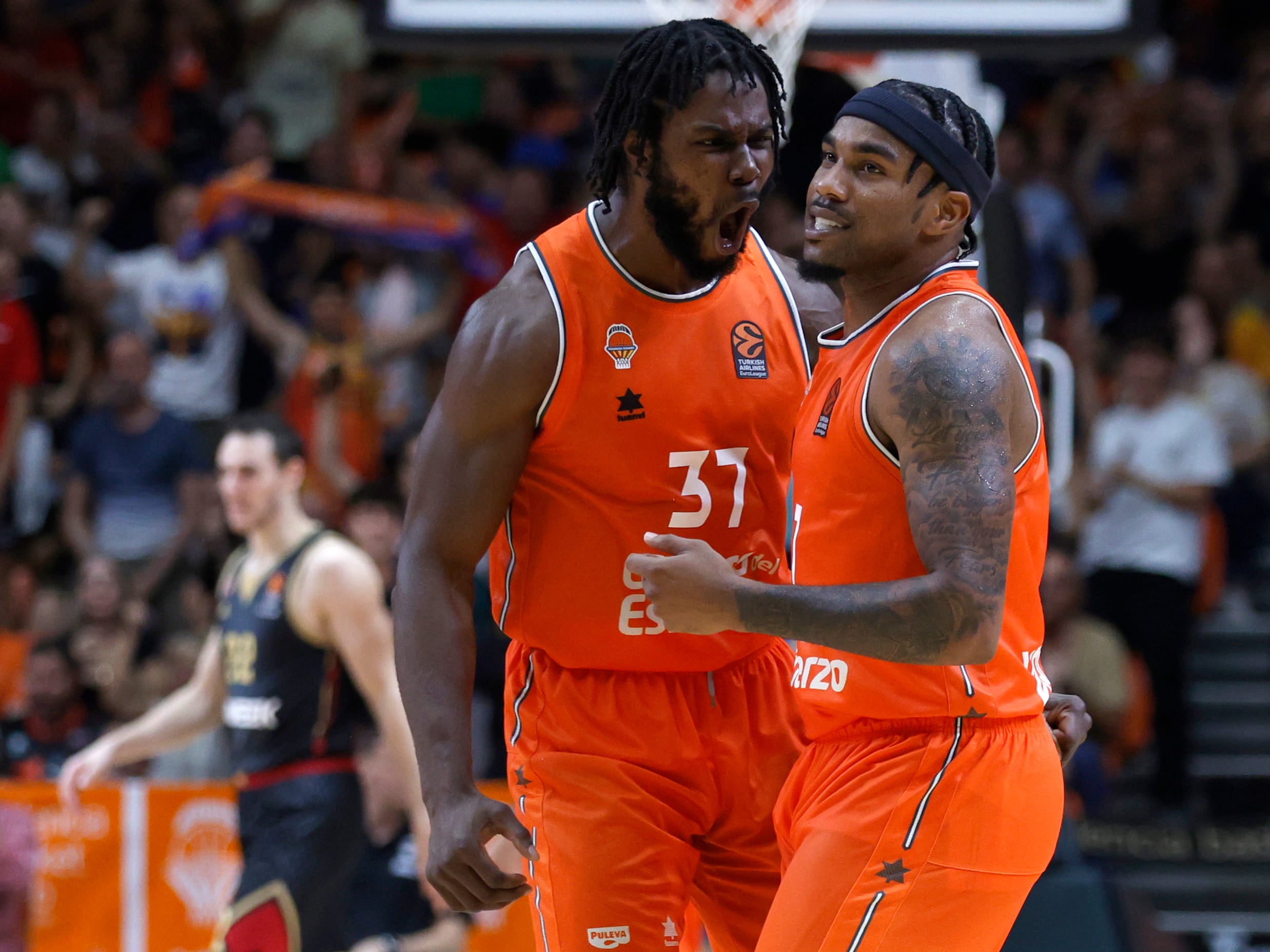 Los jugadores del Valencia Basket Semi Ojeleye y Chris Jones celebran la victoria tras el encuentro correspondiente a la fase regular de la Euroliga que disputaron hoy viernes frente al AS Mónaco en el pabellón de la Fuente de San Luis, en Valencia. EFE/ Miguel Ángel Polo.