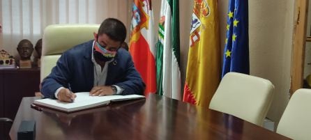 Francisco Reyes firma en el libro de honores del ayuntamiento de Huessa