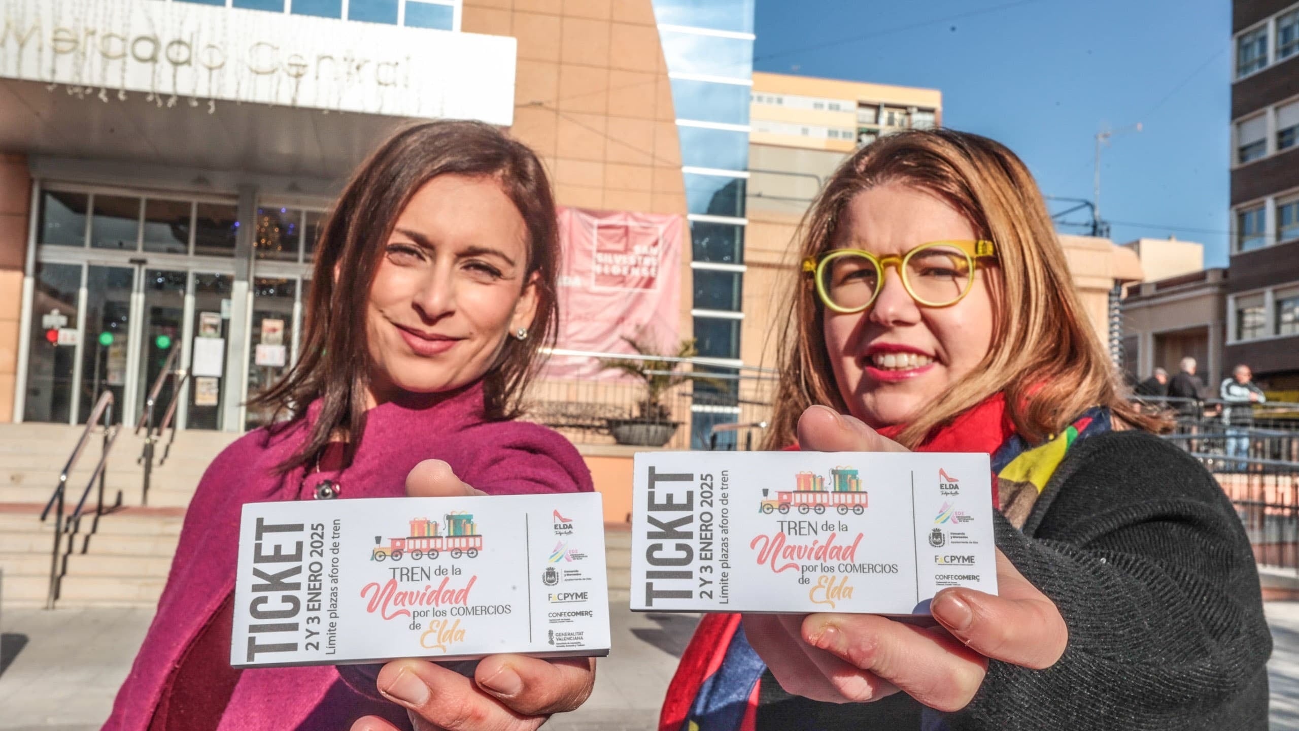 La concejala de Comercio y Mercados de Elda, Silvia Ibáñez; y la presidenta de AEDE, Rocío Vera; han presentado este jueves el Tren de la Navidad