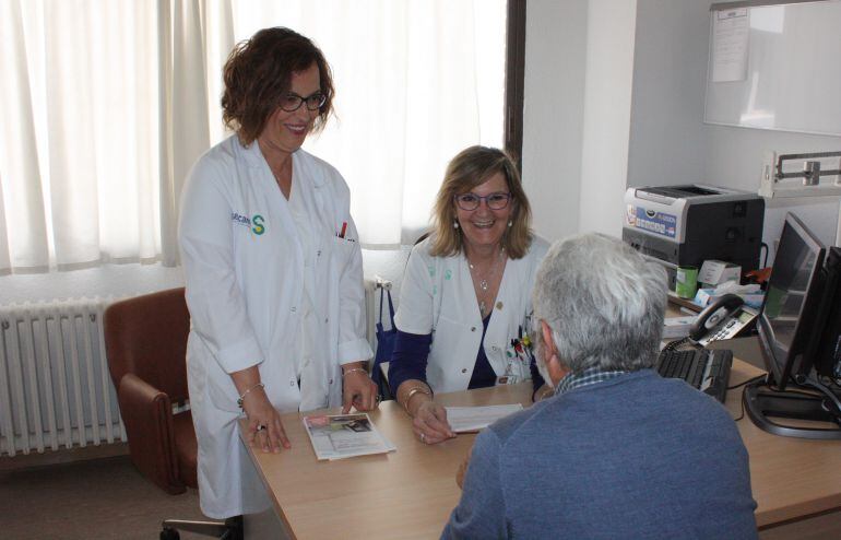 Las enfermeras Mila Serrano (d) y Ana Naranjo (i) atendiendo a un paciente en la consulta de esclerosis