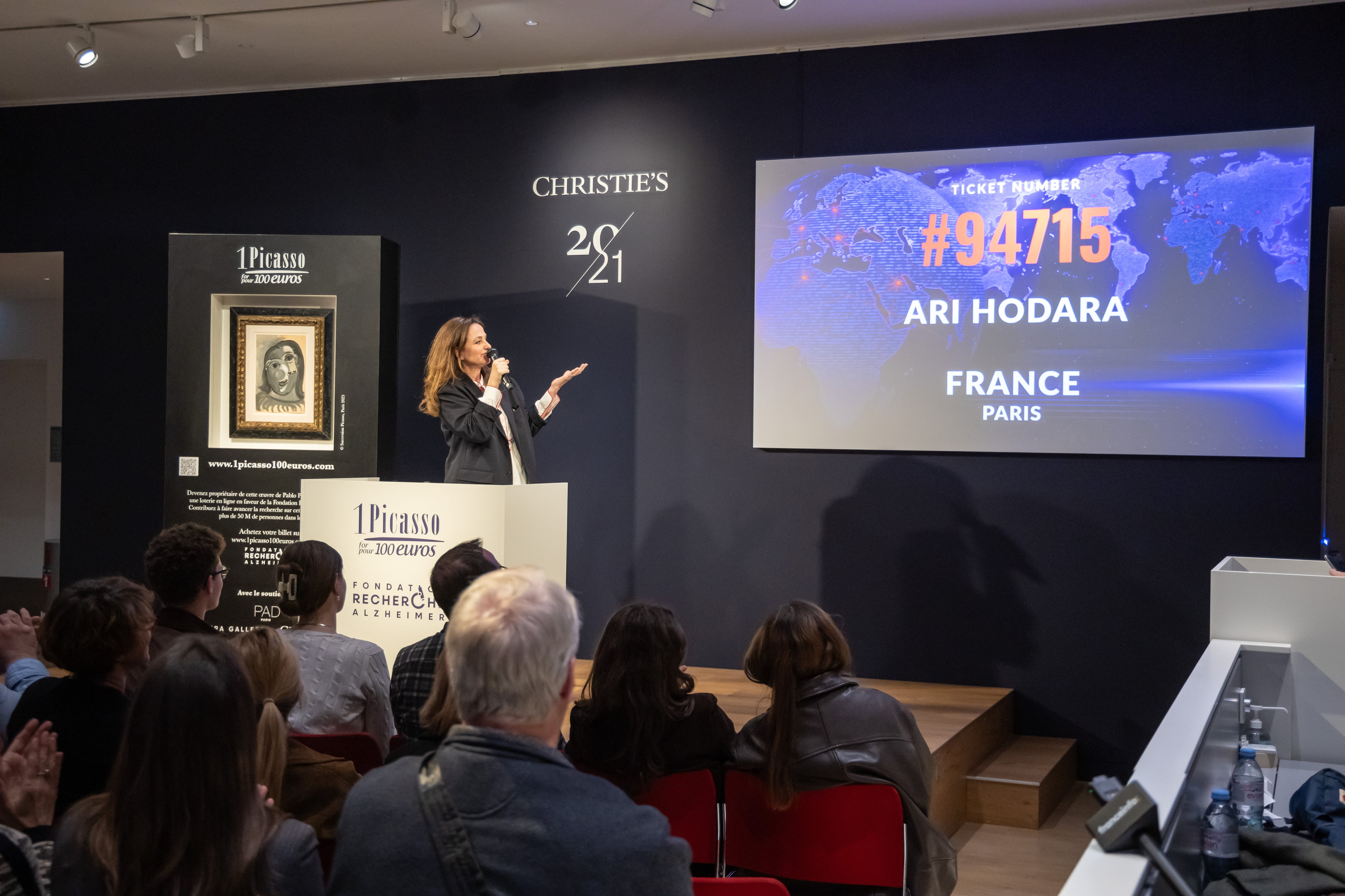 Peri Cochin, fundadora de la rifa solidaria '1 Picasso por 100 euros', anuncia el nombre del ganador del cuadro 'Cabeza de mujer' en París.
