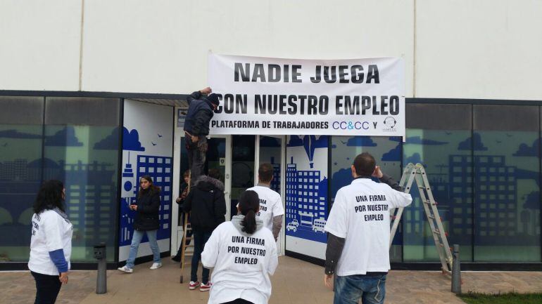 Trabajadores ubicando la pancarta de protesta