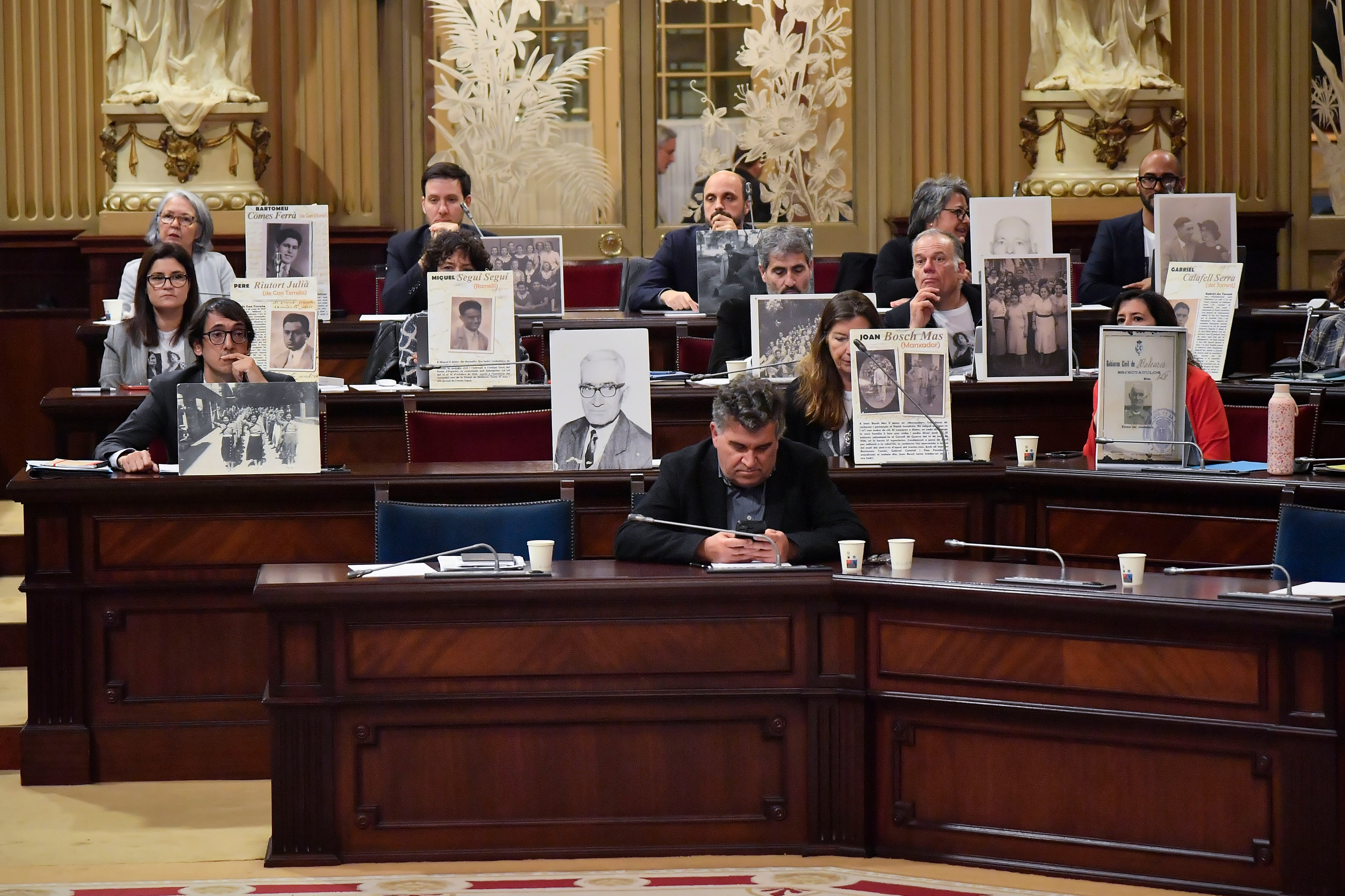 PALMA, 10/03/2026.- Diputados socialistas muestran retratos de víctimas de la Guerra Civil durante el pleno del Parlament balear que ha derogado este martes la Ley de Memoria Democrática, este martes en Palma. La propuesta de Vox ha contado con el apoyo del PP y la oposición de todos los partidos de izquierda de la Cámara legislativa. EFE/ Miquel A. Borràs