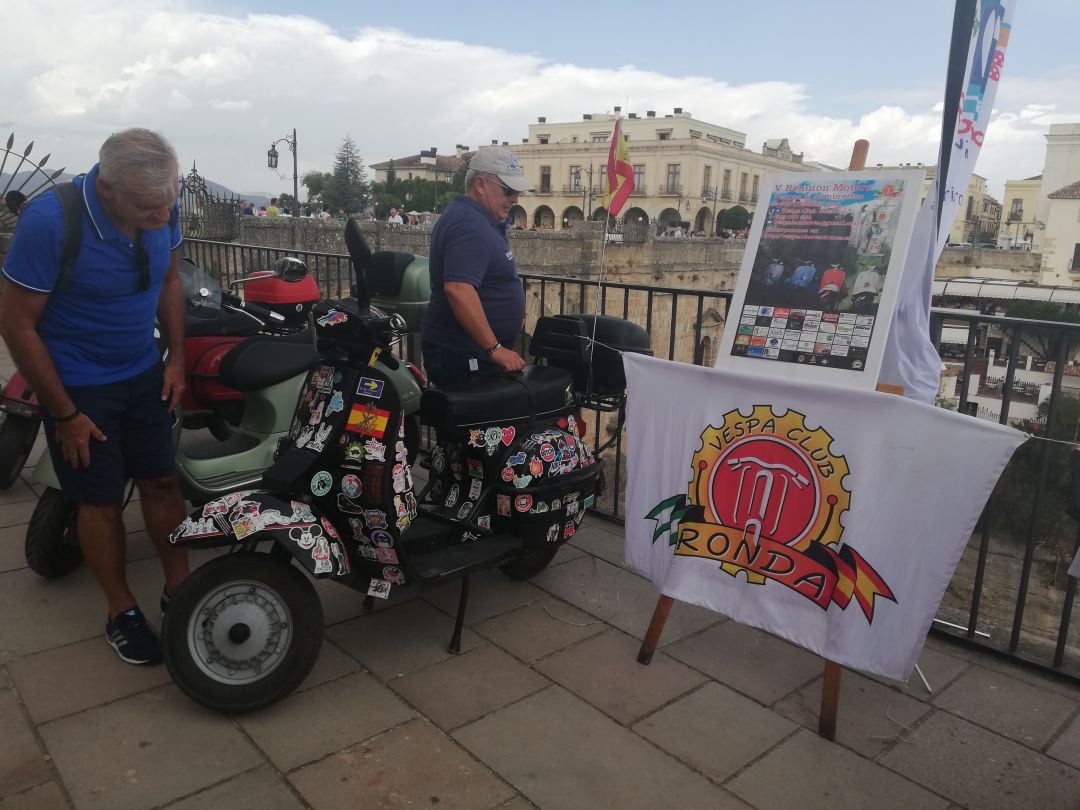 Un turista observa uno de los vehículos del Vespa Club Ronda en el mirador de Aldehuela, donde se ha realizado la presentación del evento