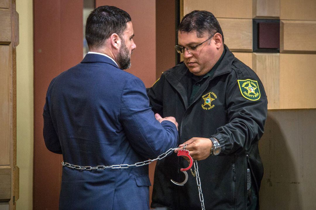 Un agente de la Oficina del Alguacil del Condado de Broward coloca las esposas al hispano-estadounidense Pablo Ibar (i) durante su juicio de hoy, en el tribunal estatal de Florida, en Fort Lauderdale, Florida