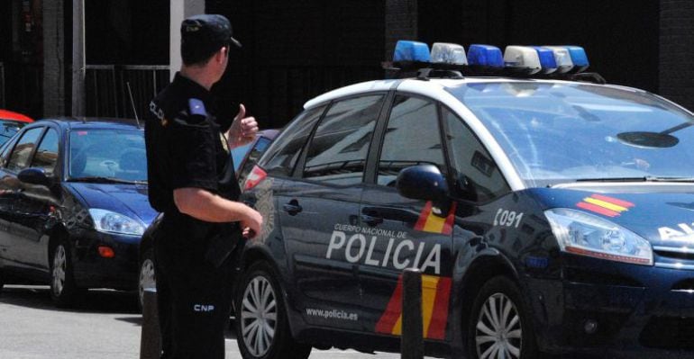 Un Policía Nacional frente a uno de los vehículos del cuerpo. 