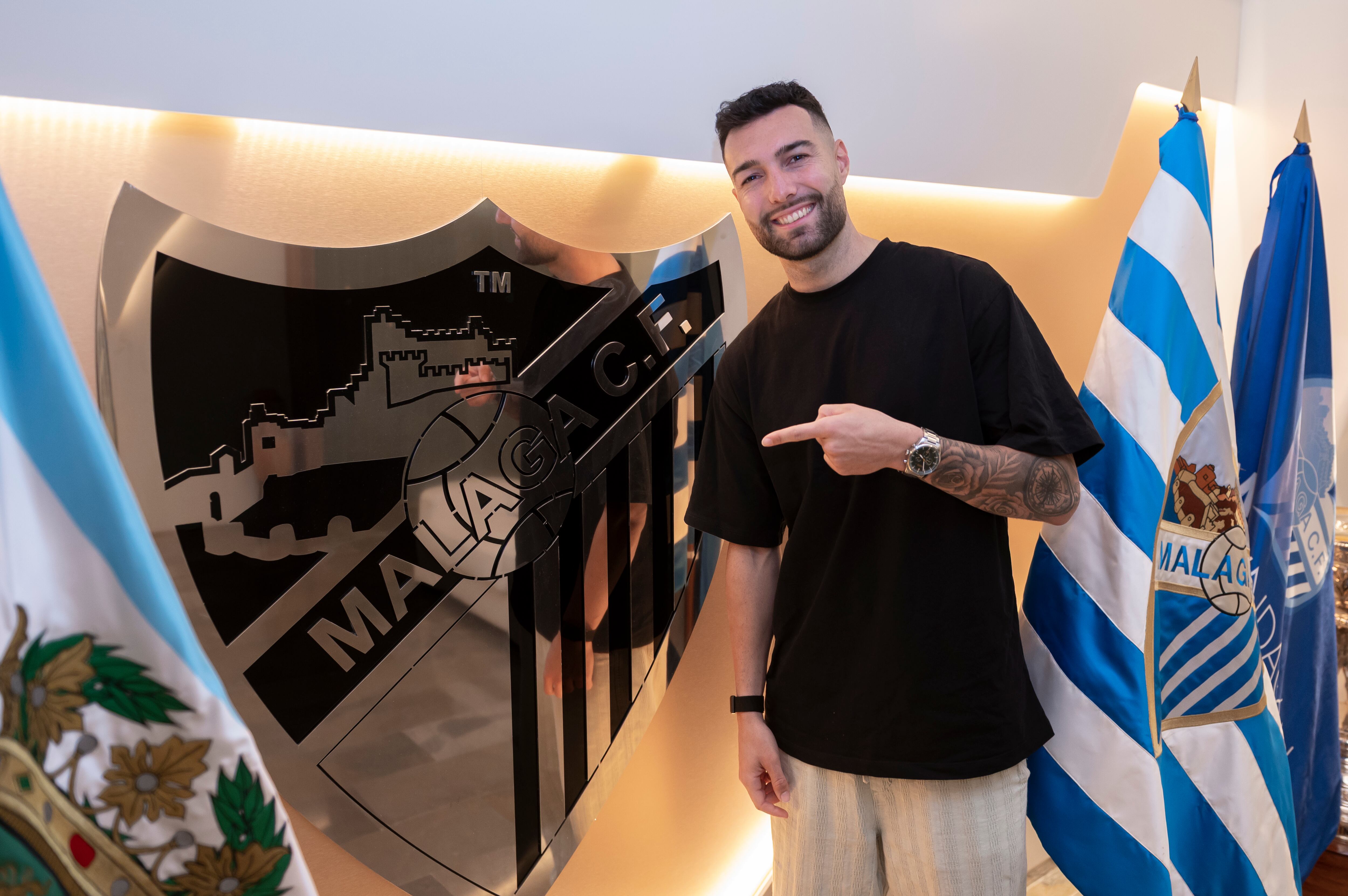 Álex Pastor, señalando el escudo del Málaga el día de su renovación