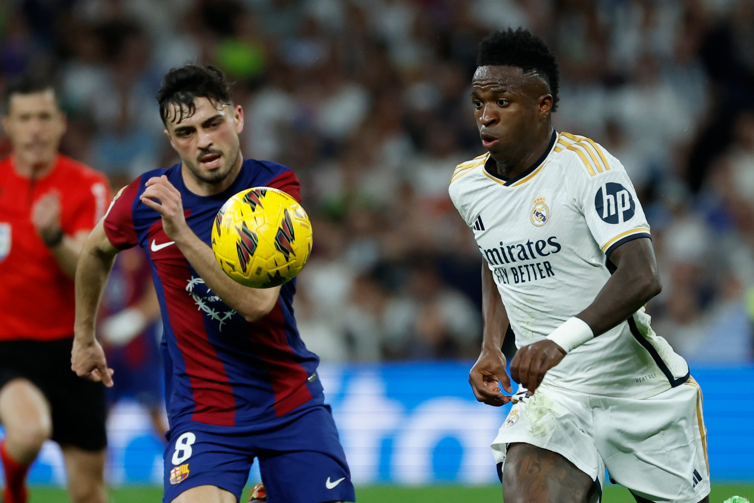 El centrocampista del FC Barcelona Pedri lucha con el brasileño Vinicius Jr., del Real Madrid, durante el partido de la jornada 32 de LaLiga EA Sports entre Real Madrid y FC Barcelona.