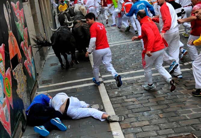 Los corredores pasan junto a uno de los toros del segundo encierro de los sanfermines