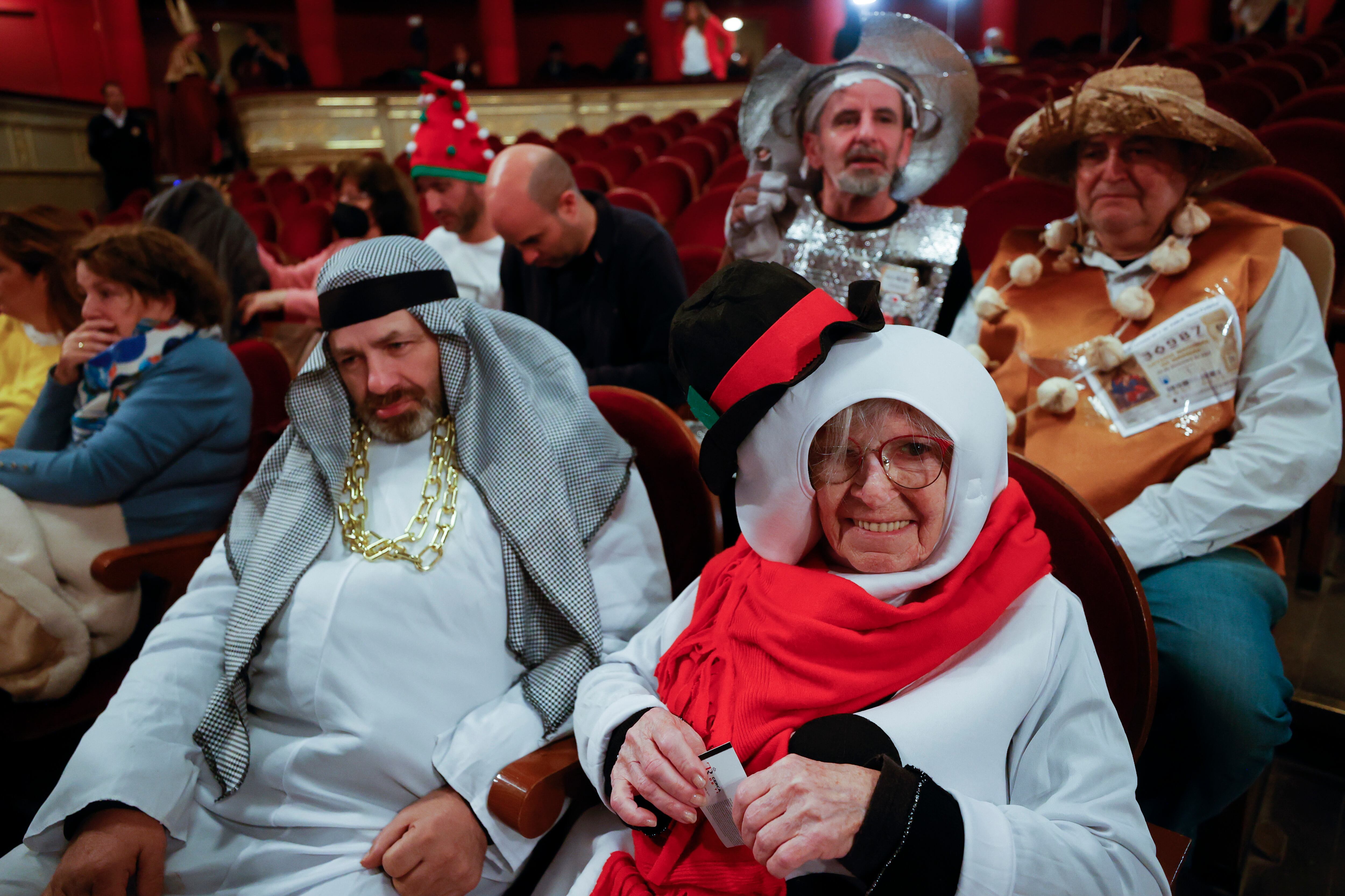 Varias personas disfrazadas esperan el comienzo del sorteo de El Gordo de Navidad en el Teatro Real en Madrid, este jueves. EFE/ Javier Lizón