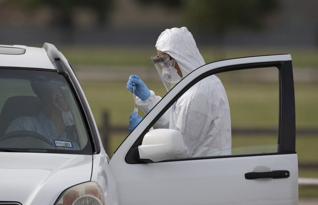 Un trabajador sanitario en Texas realiza la prueba de Covid-19 a un hombre en el interior de su vehículo.