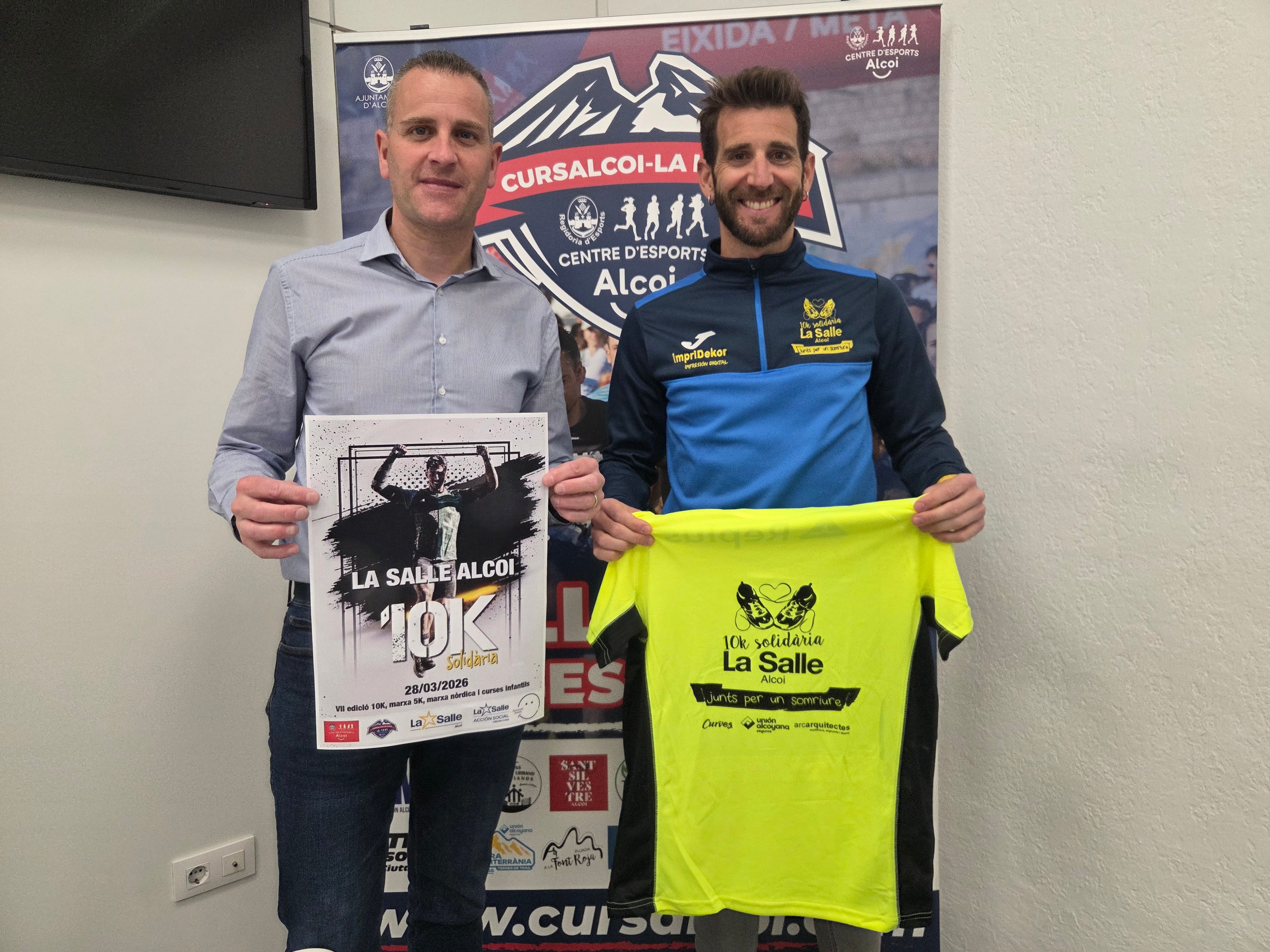 Alberto Belda y Àlex Olcina al finalizar la rueda de prensa de la carrera posan con el cartel y la camiseta de la prueba