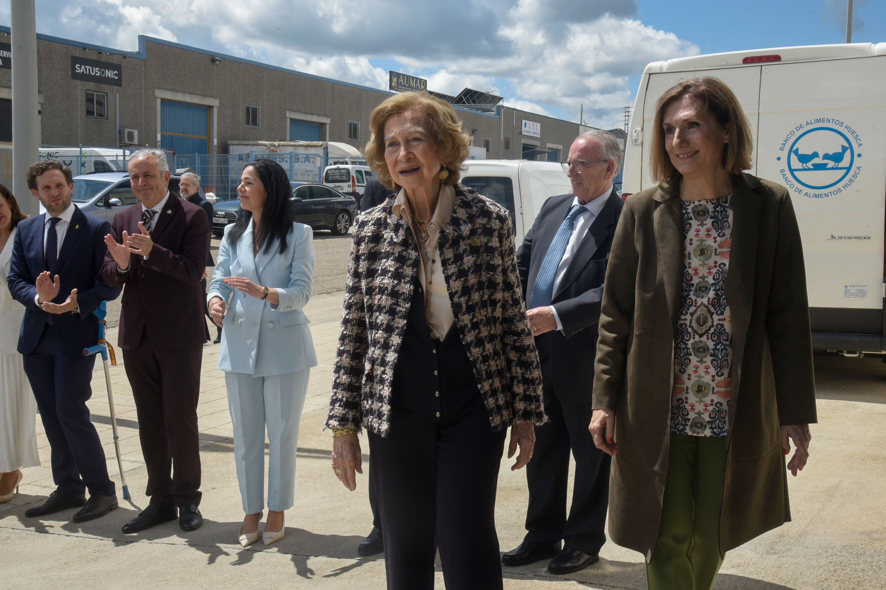 La reina Sofía a su llegada este martes las instalaciones del Banco de Alimentos de Huesca. A su lado, parte de las autoridades que la recibieron y Julia Lera, responsable del Banco de Alimentos de Huesca. EFE/ Javier Blasco