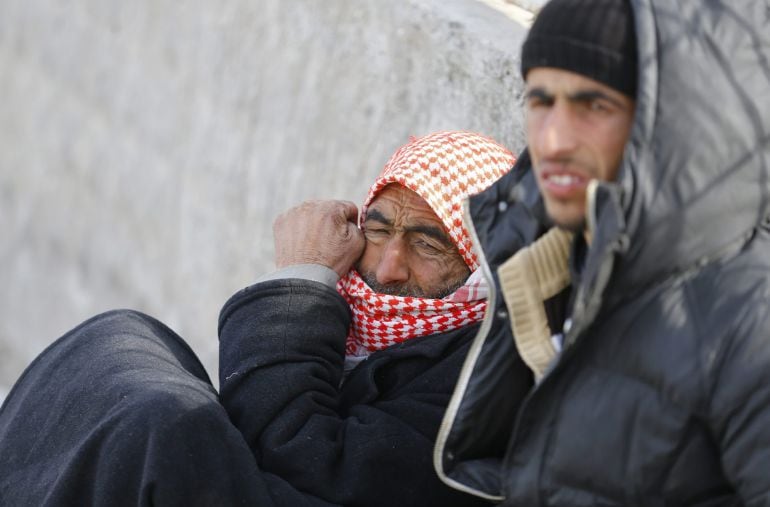 Refugiados sirios esperan sentados junto a la puerta fronteriza de Oncupinar en la ciudad de Kilis, Turquía. Miles de sirios que han huido de los recientes bombardeos rusos en Alepo se encuentran varados cerca de la frontera 