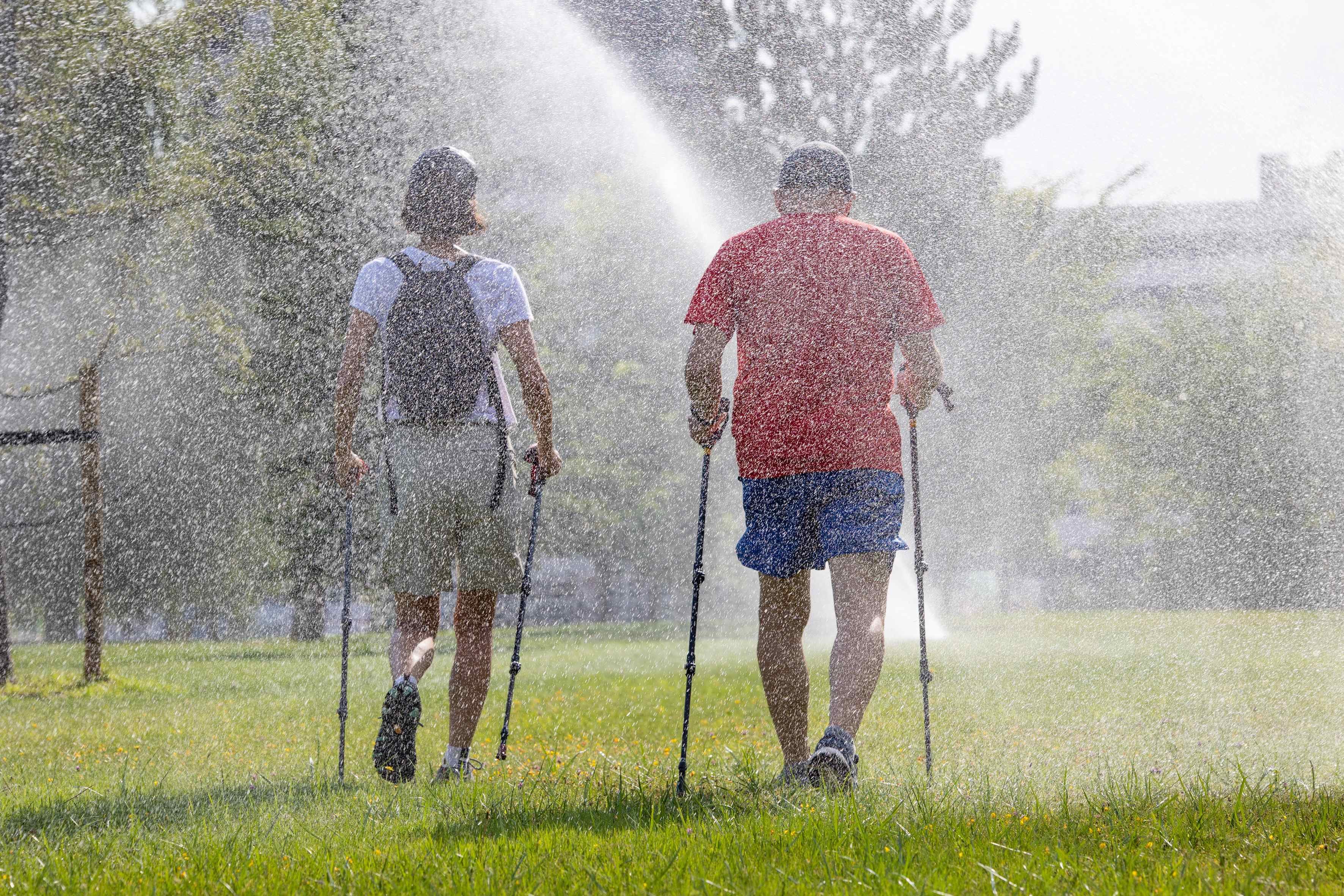 LOGROÑO 10/08/2024.- Unos caminantes se refrescan bajo los aspersores este sábado en Logroño. Diez comunidades autónomas se encuentran este sábado en alerta naranja debido a las temperaturas extremas, por encima de los 40 grados, que se alcanzarán en la cuarta ola de calor del verano: Andalucía, Aragón, Castilla y León, Castilla-La Mancha, Cataluña, Extremadura, Galicia, Madrid, Navarra y La Rioja.- EFE/Raquel Manzanares