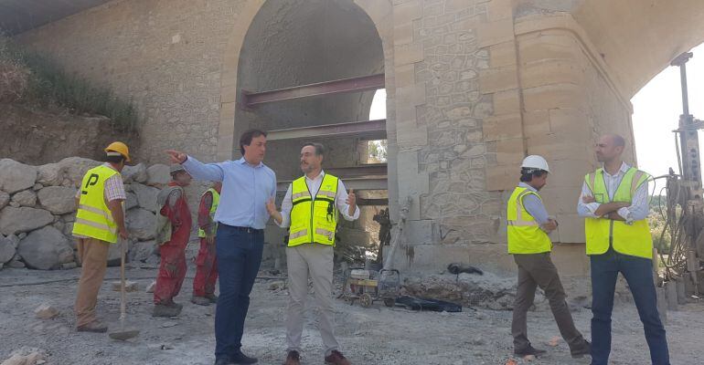 El delegado de Fomento, José Manuel Higueras y el consejero del área, Felipe López, dialogan justo debajo del Puente sobre el Arroyo Salado, en Porcuna.