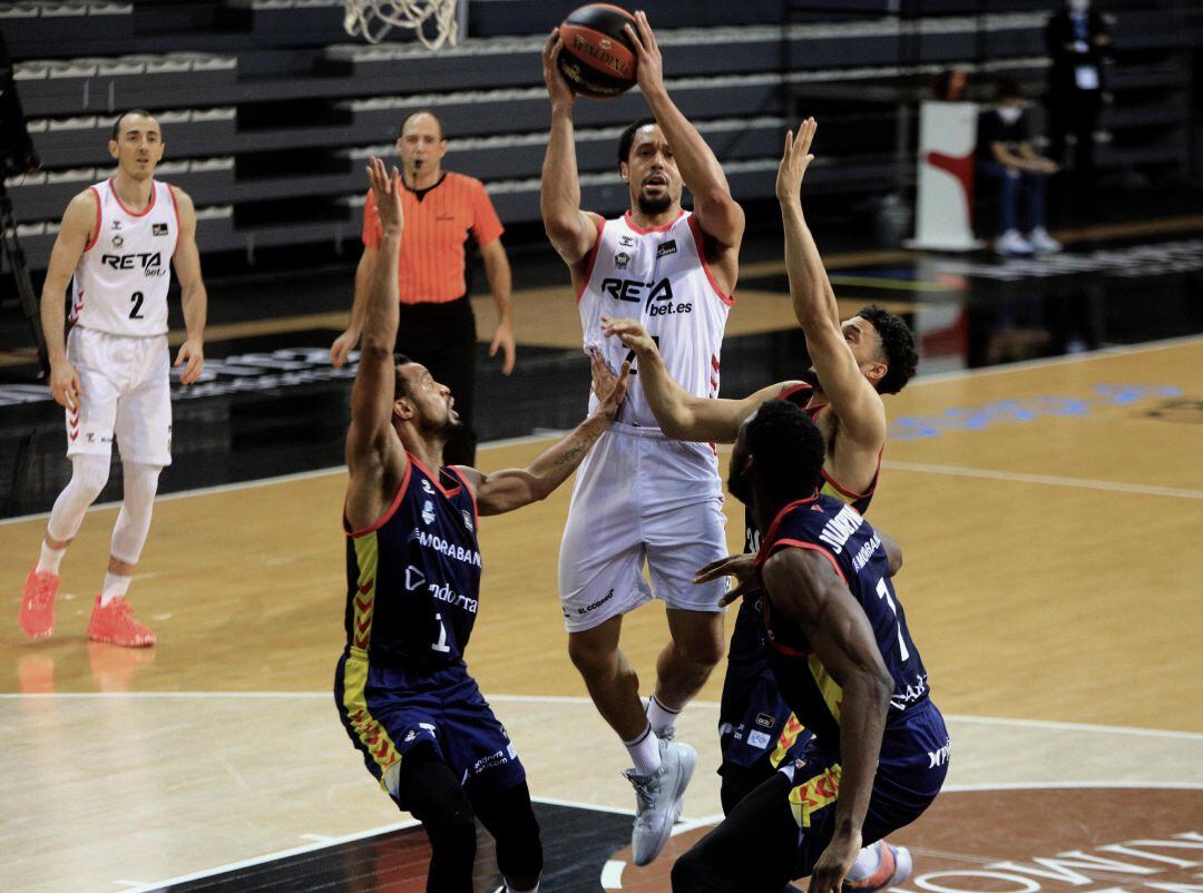 El escolta estadounidense del RETAbet Bilbao Basket John Jenkins (c) se eleva por encima de los jugadores del Morabanc Andorra durante el partido correspondiente a la vigésima jornada de la Liga Endesa disputado este domingo en el pabellón Poliesportiu d&#039;Andorra en Andorra La Vella.