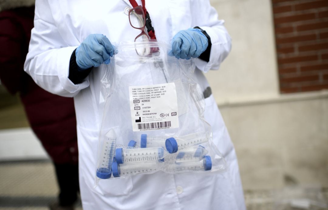 Un sanitario con tubos de ensayo durante la realización de tests.
