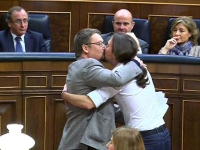 El líder de Podemos, Pablo Iglesias y el de En Comú Podem, Xavier Doménech, se besan en los labios al término de la intervención del diputado catalán.