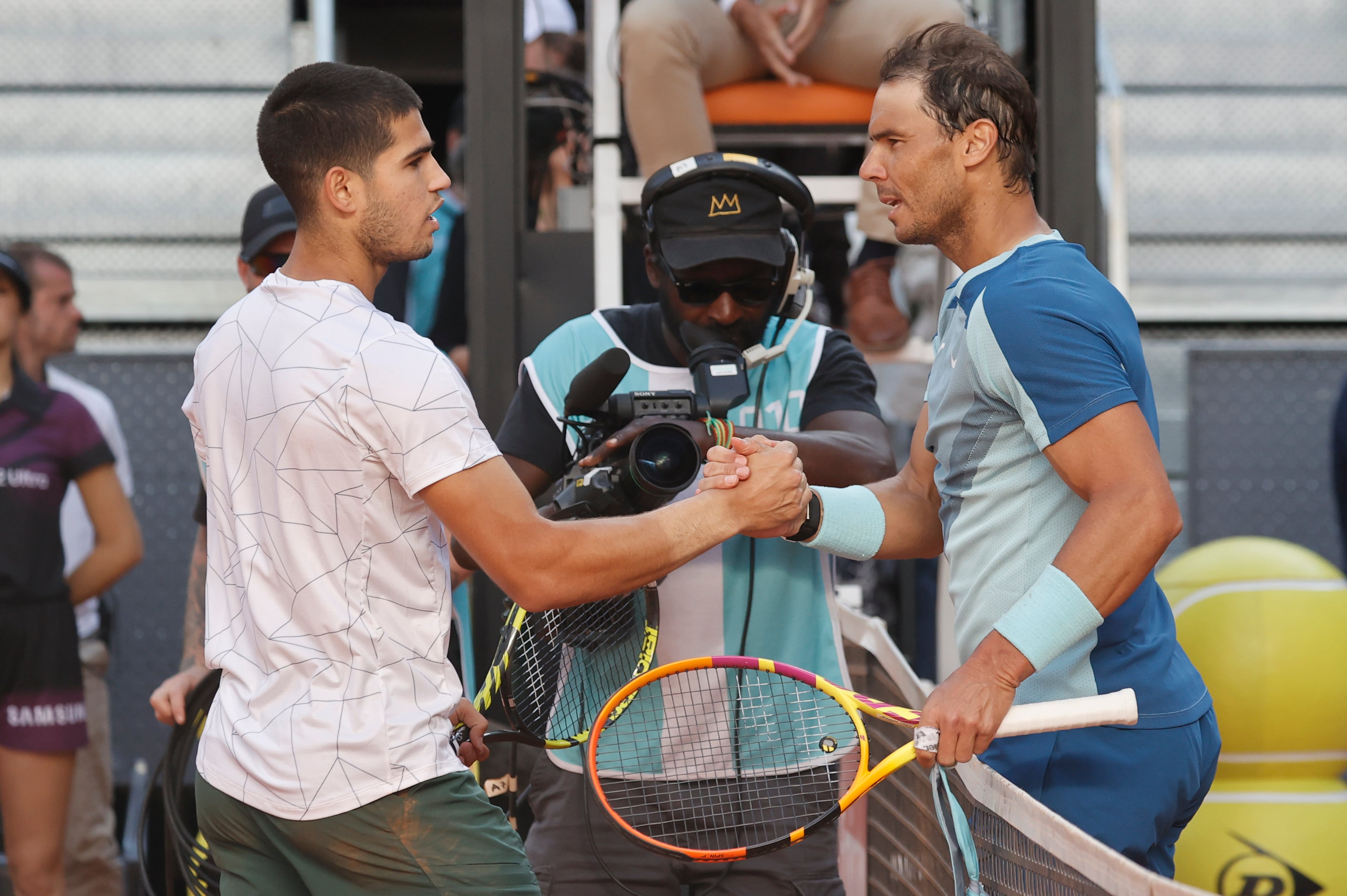 El tenista Carlos Alcaraz, y el tenista Rafael Nadal, se estrechan la mano tras el encuentro de cuartos de final del Mutua Madrid Open este viernes en la Caja Mágica en Madrid.