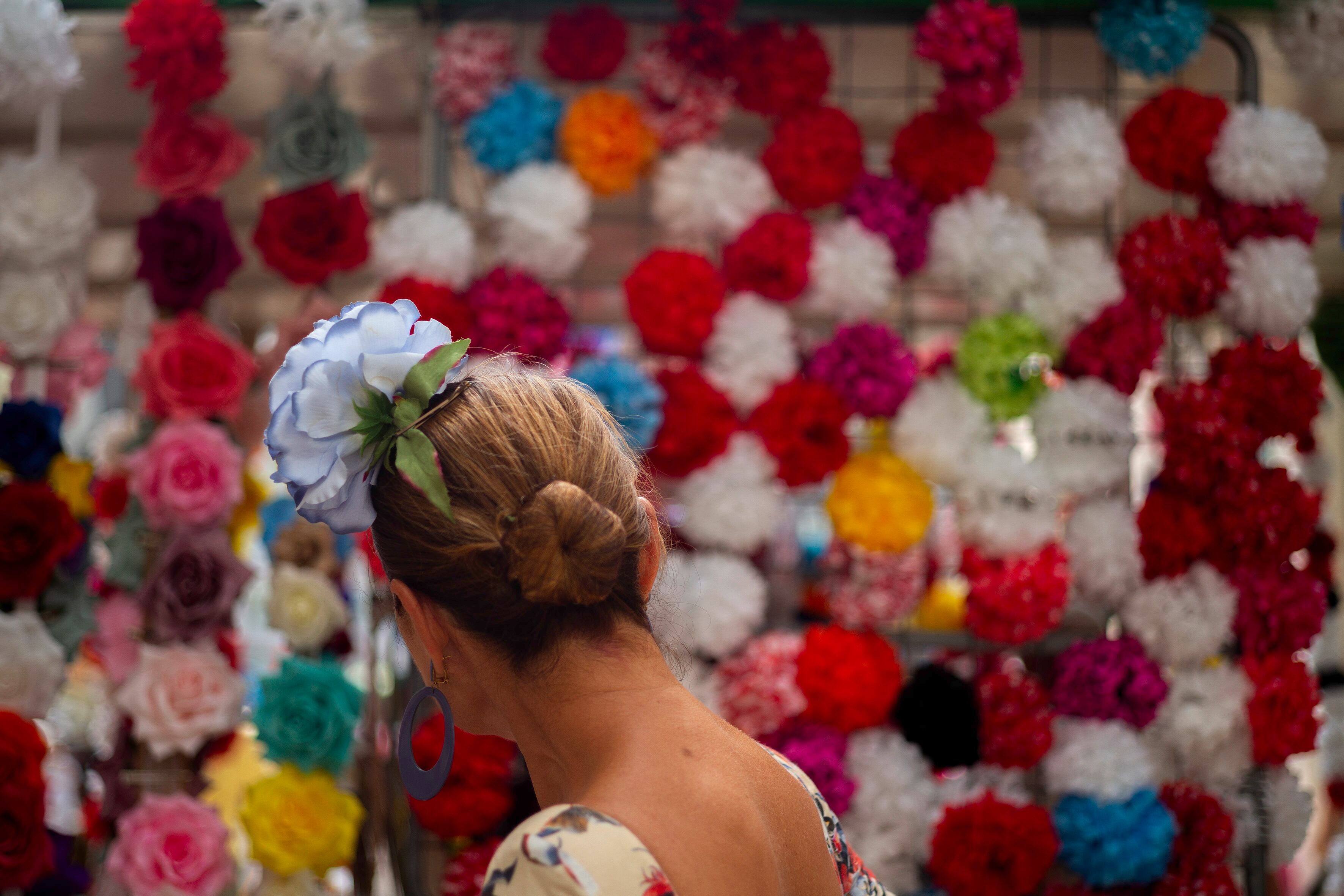 -FOTODELDÍA- MÁLAGA, 21/08/2024.-Una mujer vestida de flamenca pasea por la Feria del centro de Málaga, en la quinta jornada que se alarga hasta el 24 de agosto..EFE/Jorge Zapata.
