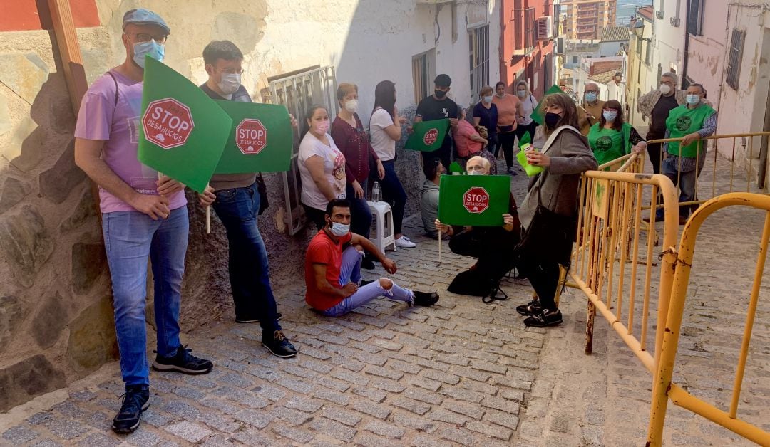 David (sentado y con camiseta roja) y Tamara (con camiseta blanca y de pie) y varios miembros de la PAH en la concentración ante las puertas de su vivienda.