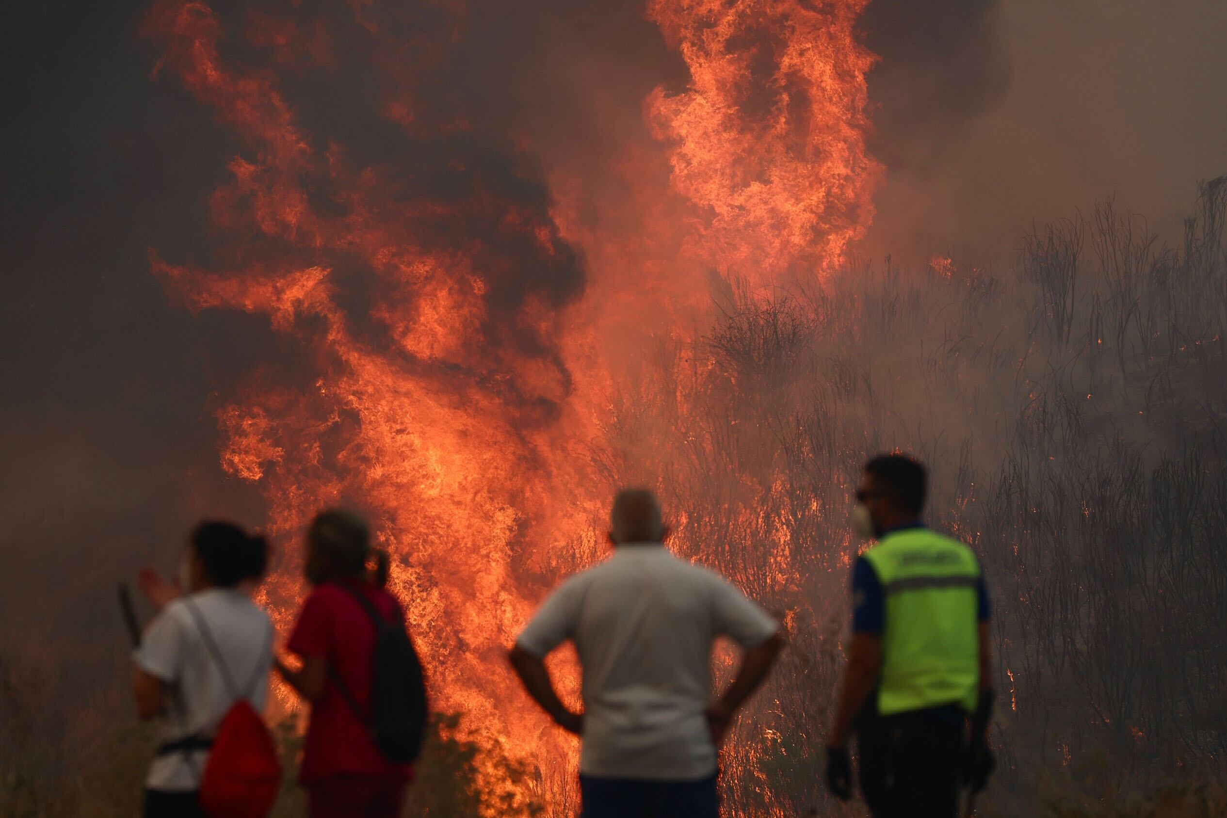 GRAF8039. O CAÑIZO (OURENSE), 14/08/2025.- Varias personas luchan contra las llamas del incendio de A Gudiña (Ourense), este jueves. La DGT ha informado de que la circulación en la autovía A-52 está cortada entre los kilómetros 124 y 129 por los incendios forestales, concretamente en la zona de A Gudiña. La autovía está cortada en ese tramo en ambos sentidos y también está afectada la N-525 en los puntos kilométricos 129 y 86. EFE/ Sxenick