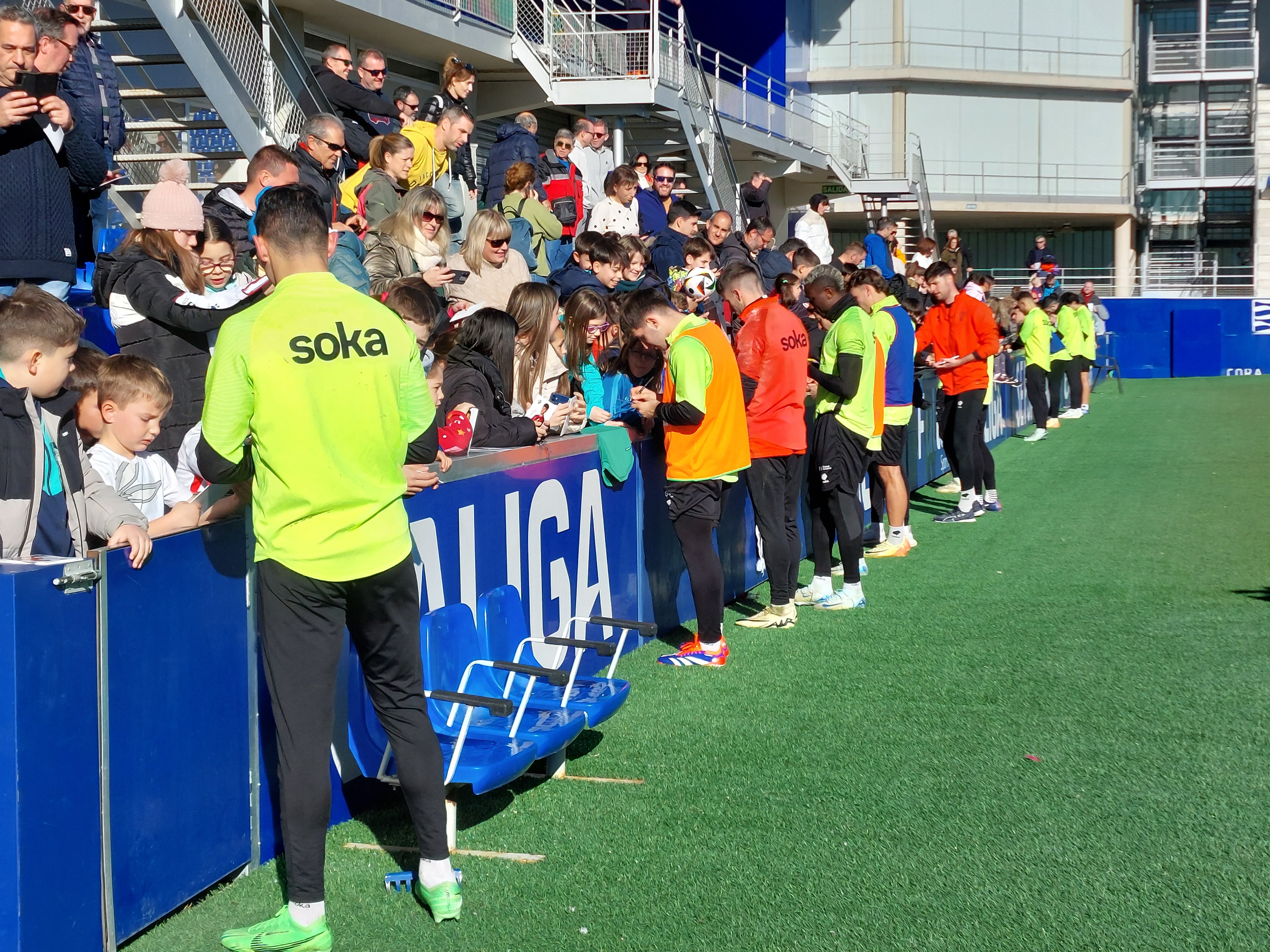 Los jugadores de la SD Huesca firmando autógrafos a los aficionados en El Alcoraz