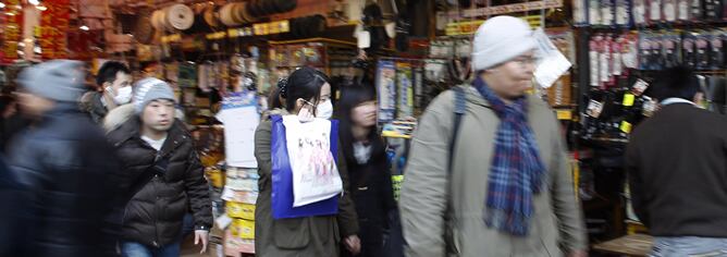 Gente pasando junto a tiendas de electrónica en el distrito de Akihabara en Tokio