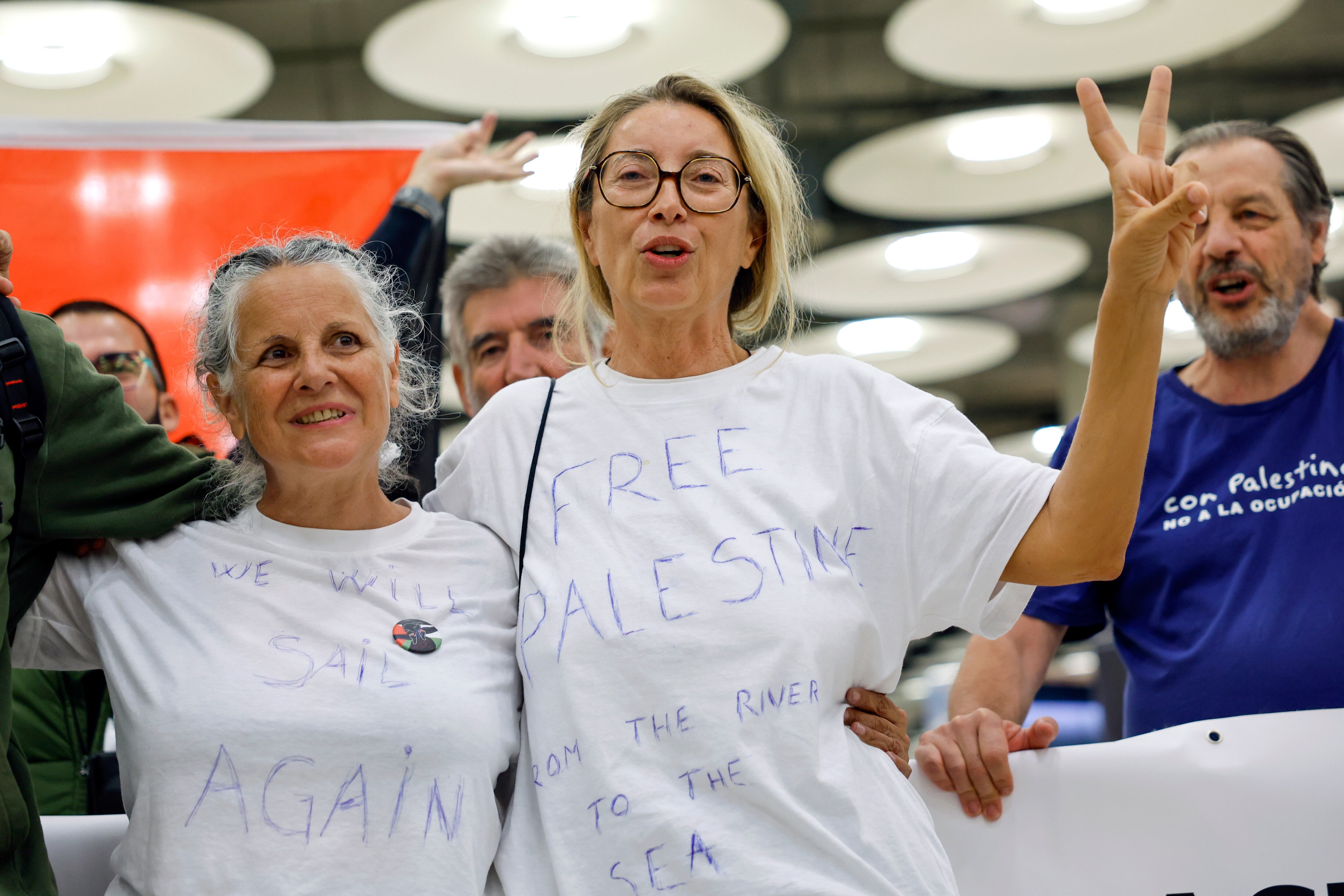 MADRID, 13/10/2025.- Las activistas miembros de la Flotilla Global Sumud Reyes Rigo (c) y Aunción Estriégana Martin (i) a su llegada al aeropuerto Adolfo Suárez Madrid-Barajas este lunes. Los cinco últimos miembros españoles de las flotillas humanitarias rumbo a Gaza interceptadas este mes por Israel que permanecían en este país han llegado en la mañana de este lunes al aeropuerto Adolfo Suárez Madrid-Barajas en un vuelo procedente de Catar, a donde fueron llevados desde Jordania. EFE/ Mariscal
