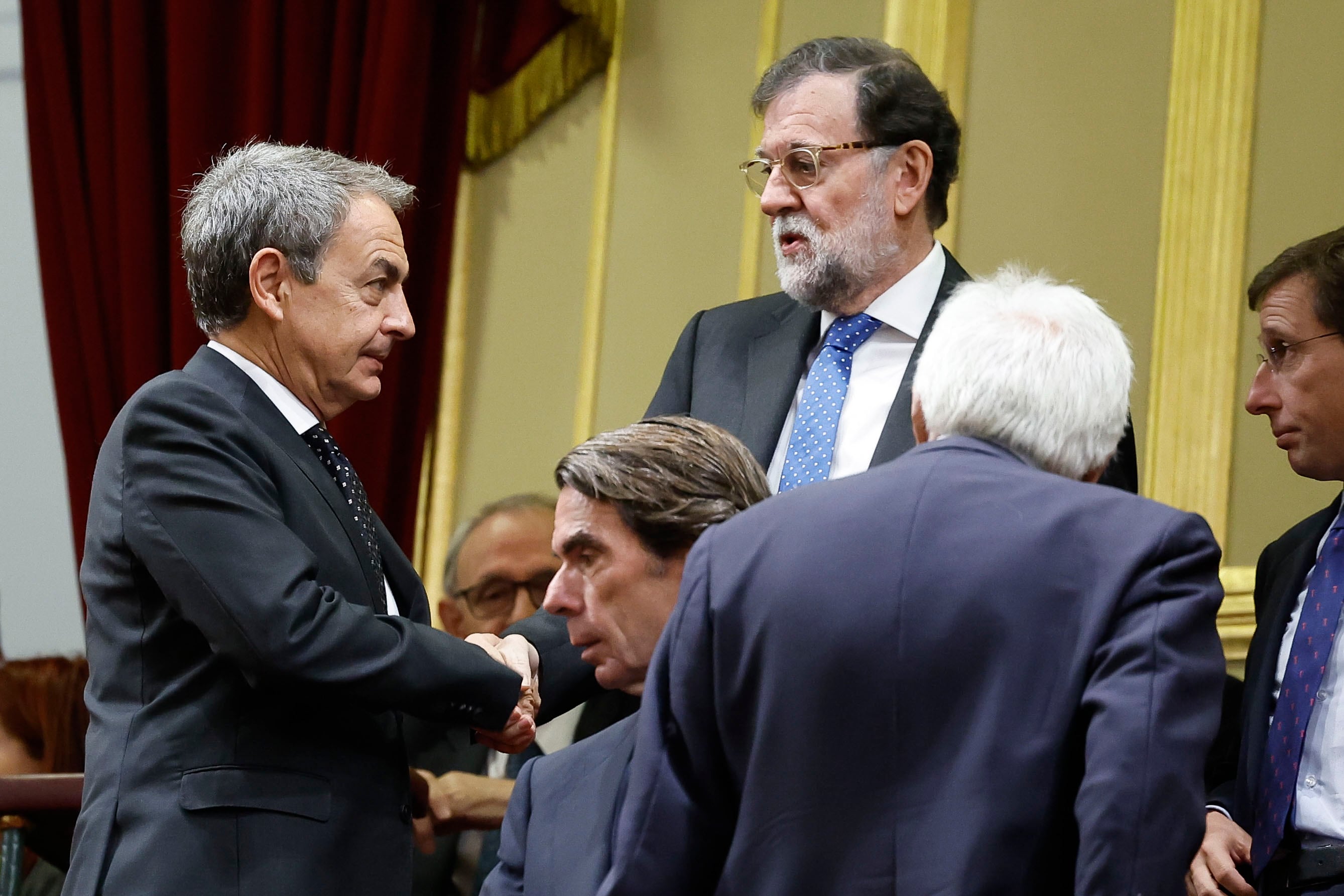 Saludo enter los expresidentes del Gobierno José Luis Rodríguez Zapatero (i) y Mariano Rajo (d).