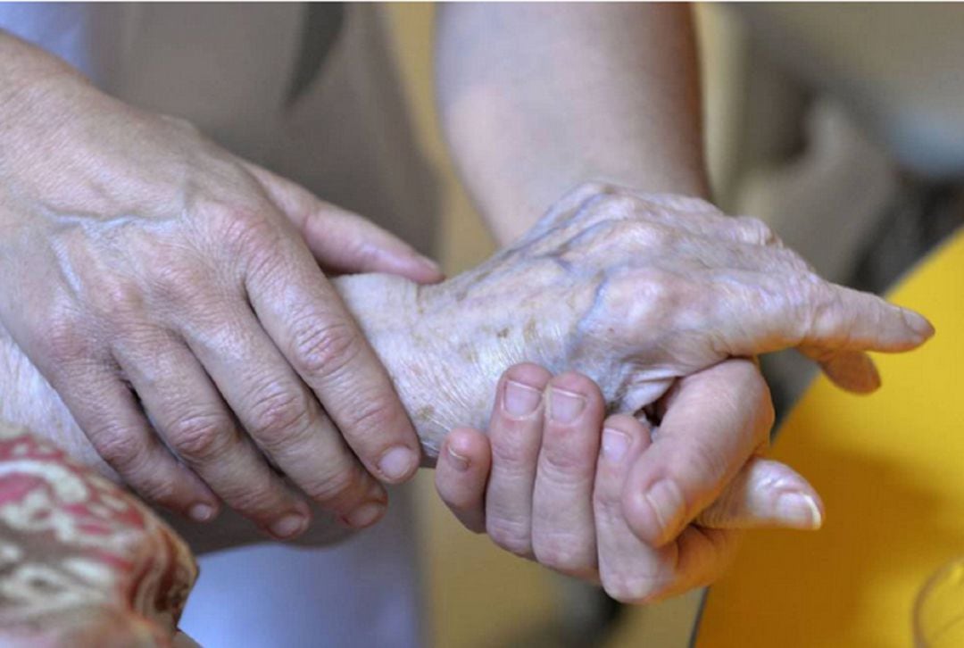 Una persona atiende a una anciana