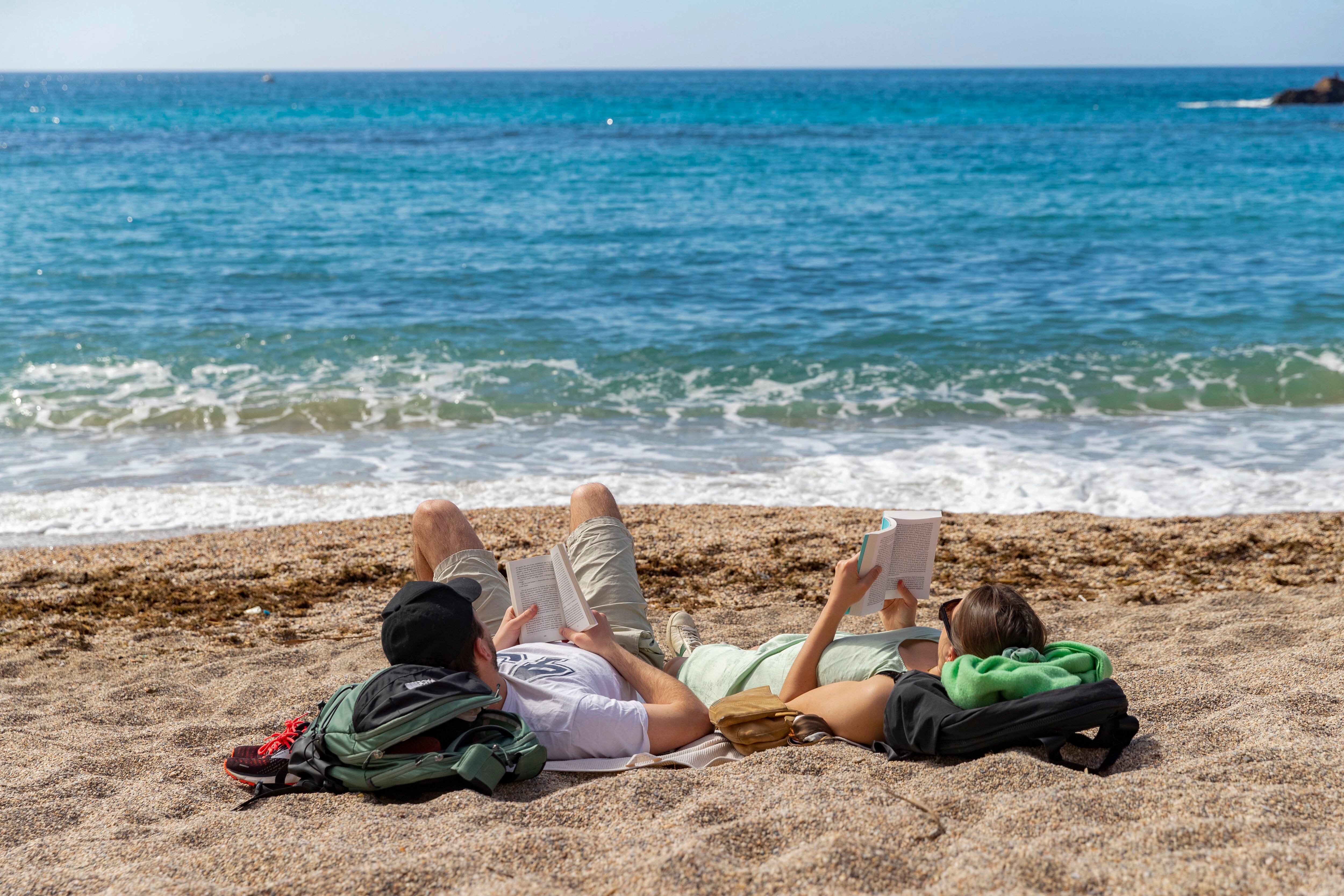 Una pareja toma el sol el miércoles en la playa de Cala Cortina de Cartagena