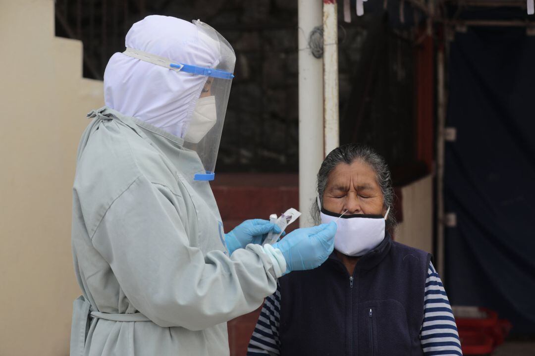A health worker takes a sample for a PCR COVID-19 test