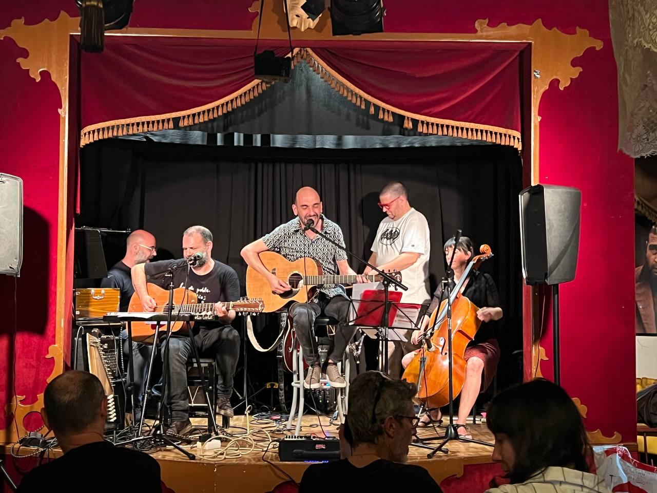 Pau Miquel Soler, acompanyat per músics, durant l'actuació al pub l'Escenari per tancar la setmana dedicada a Vicent Andrés Estellés.