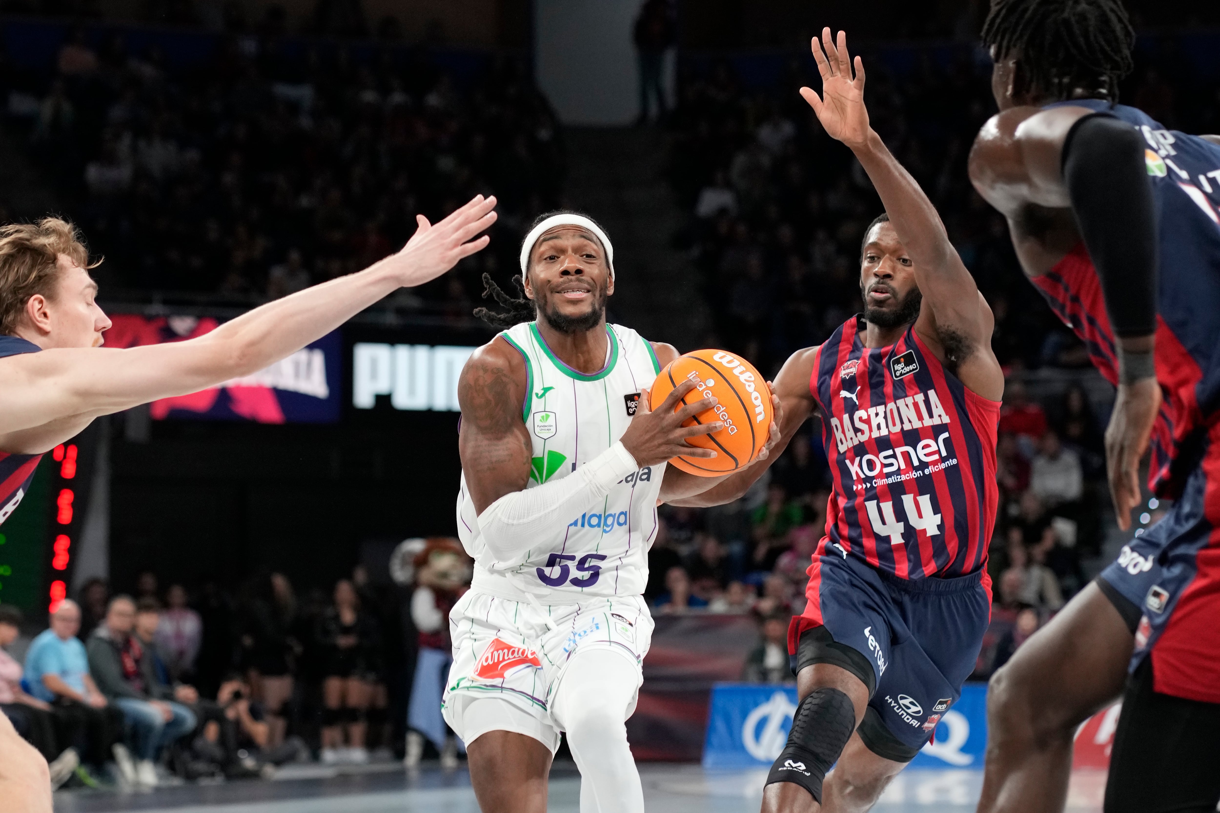 VITORIA-GASTEIZ, 22/12/2024.- El jugador del Baskonia Kamar Baldwin (d) se enfrenta a Kendrick Perry (c), del Unicaja, durante el partido de la Liga ACB de baloncesto disputado este domingo en el pabellón Fernando Buesa Arena de Vitoria-Gasteiz. EFE/Adrian Ruiz Hierro
