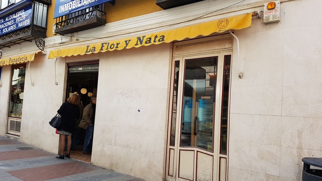 Clientes leyendo el cartel de cierre en La Flor y Nata