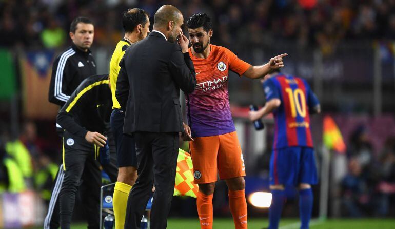 Guardiola da instrucciones a Nolito con Messi de fondo