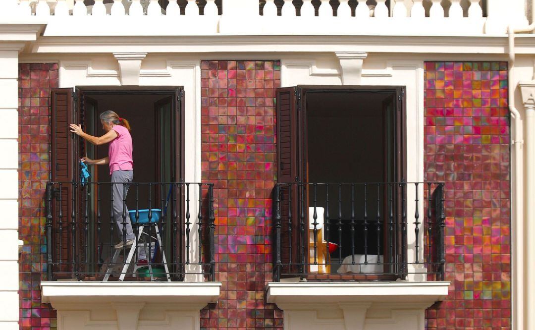 Dos mujeres limpian sus balcones en un edificio de la Parte Vieja de San Sebastián.