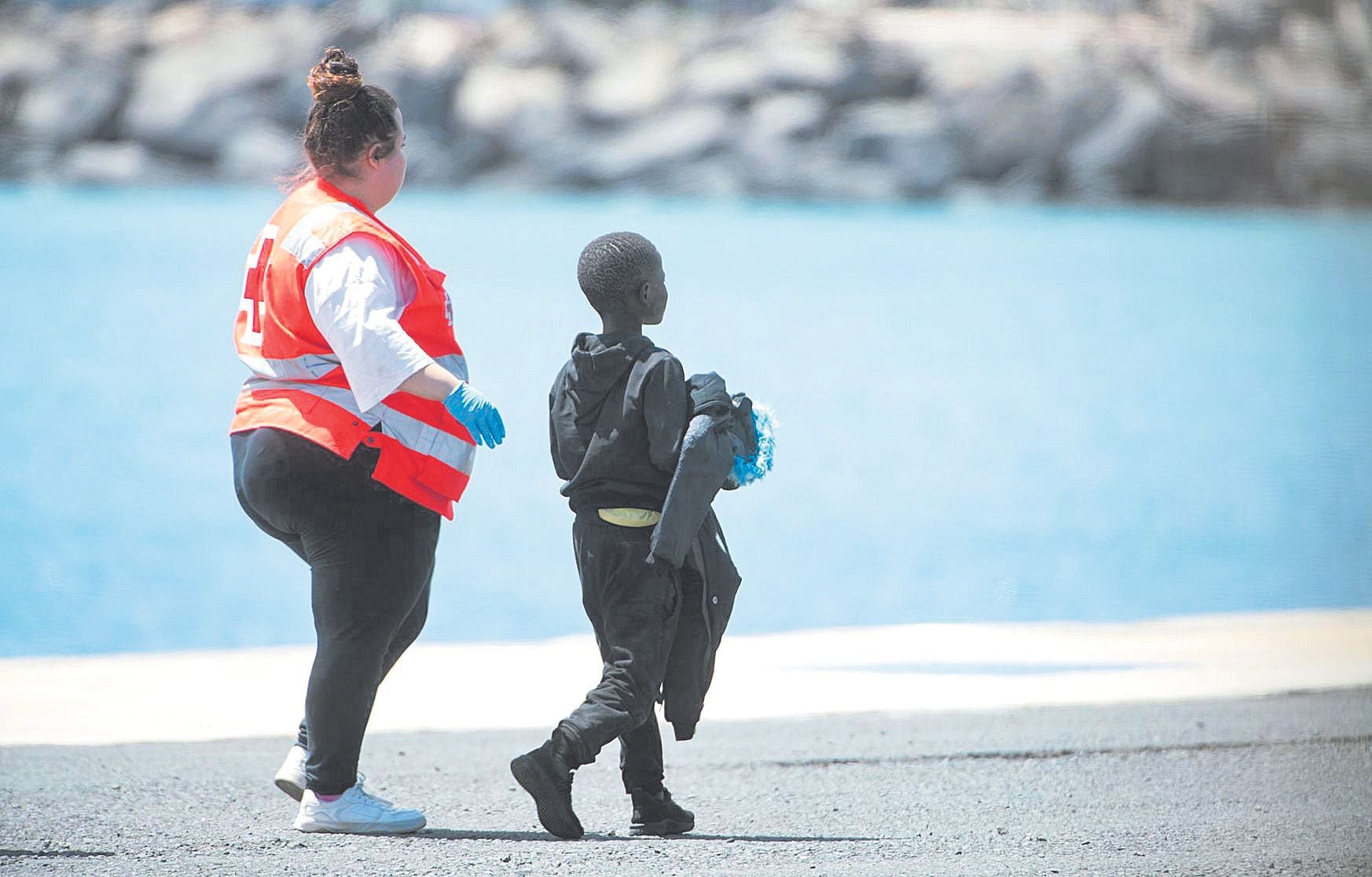 Un menor y una voluntaria de Cruz Roja en una playa de Fuerteventura
