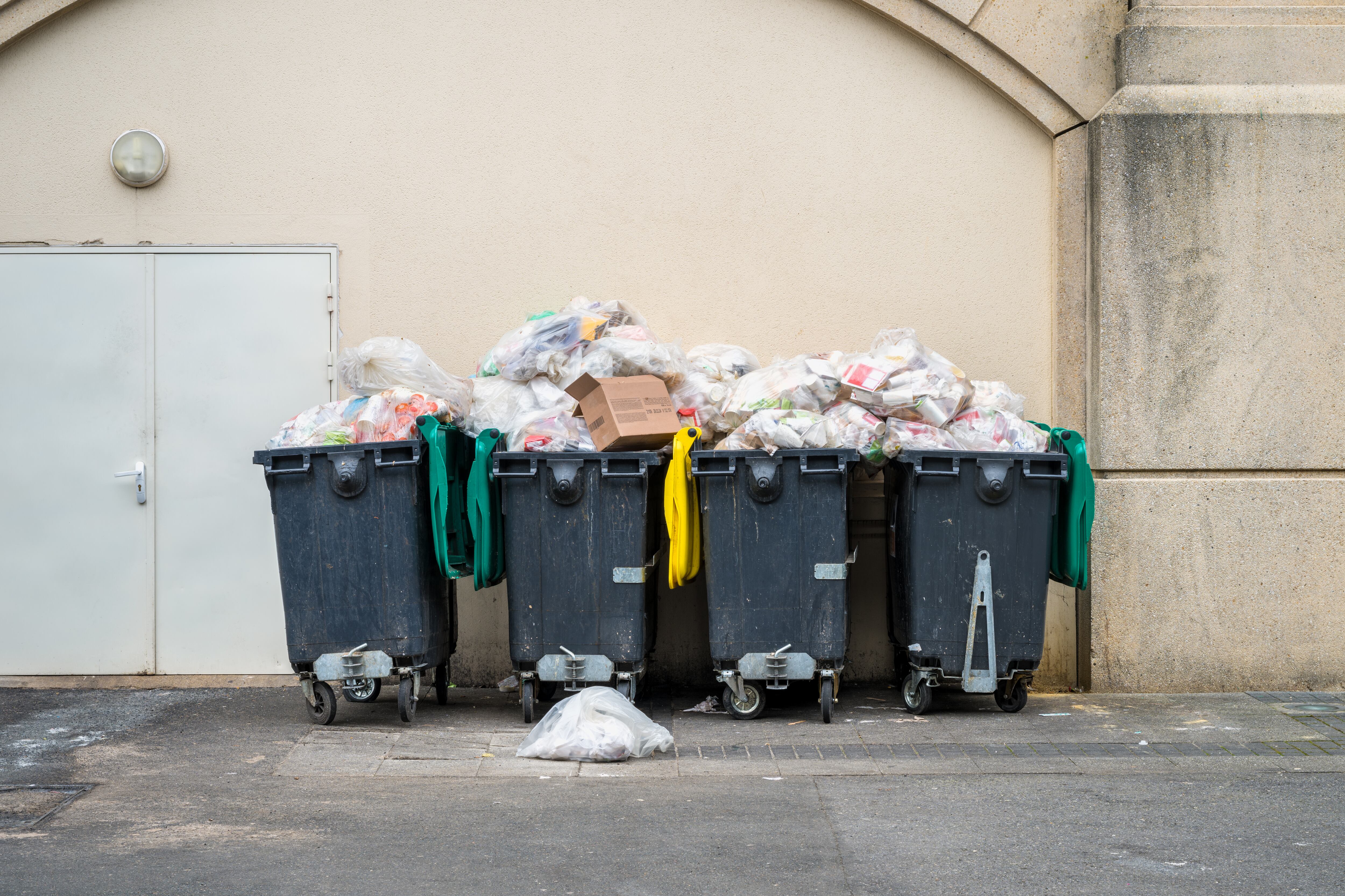 Full Dumpsters in an Alley outside a Shopping Mall in Serris, France.