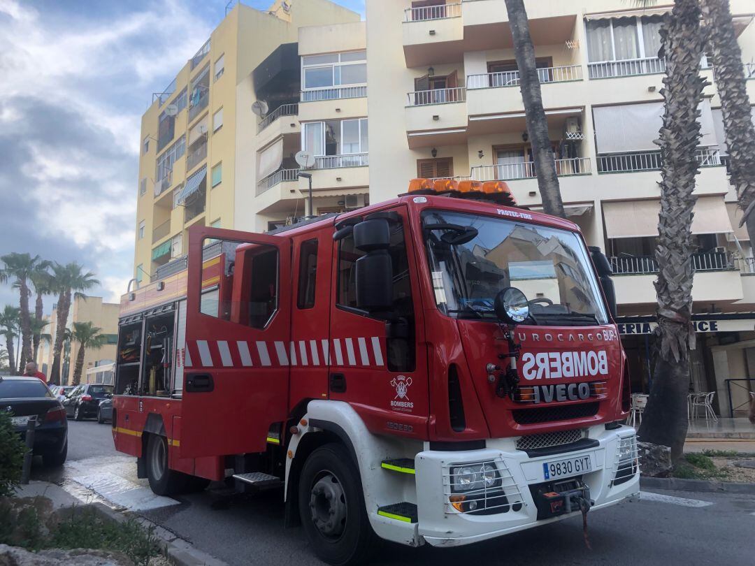 Imagen de un camión del camión de bomberos que se ha trasladado al lugar y al fondo, el piso calcinado