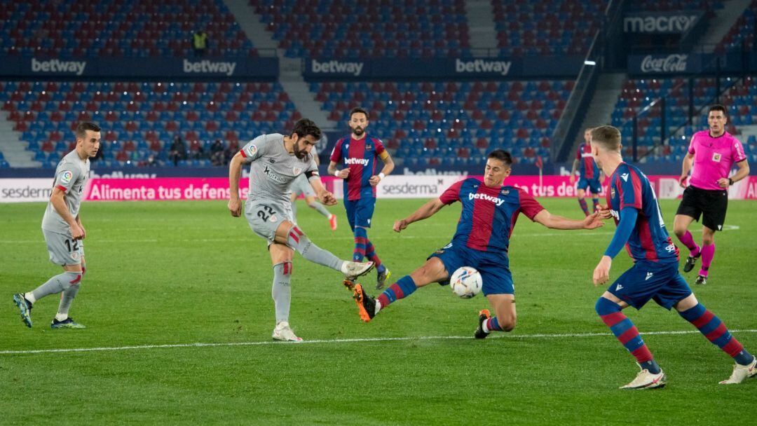 Raúl García dispara un balón ante los jugadores del Levante