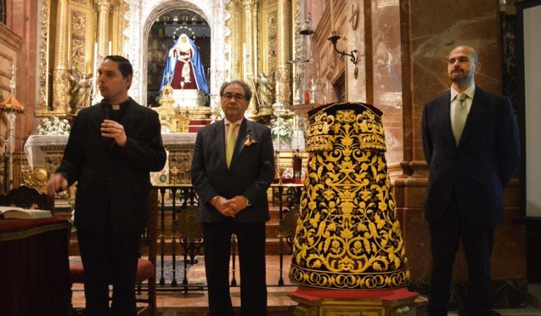 De izquierda a derecha, junto a la nueva saya, Antonio Mellet, rector de la Basílica; José Antonio Fernández Cabrero, hermnao mayor de La Macarena; y el bordados Mariano Martín Santonja