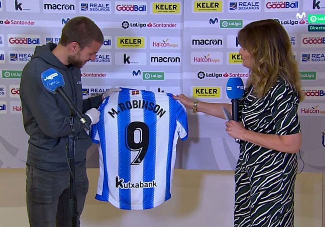 Illaramendi haciendo entrega de una camiseta de la Real Sociedad con el nombre de Michael Robinson en el dorso