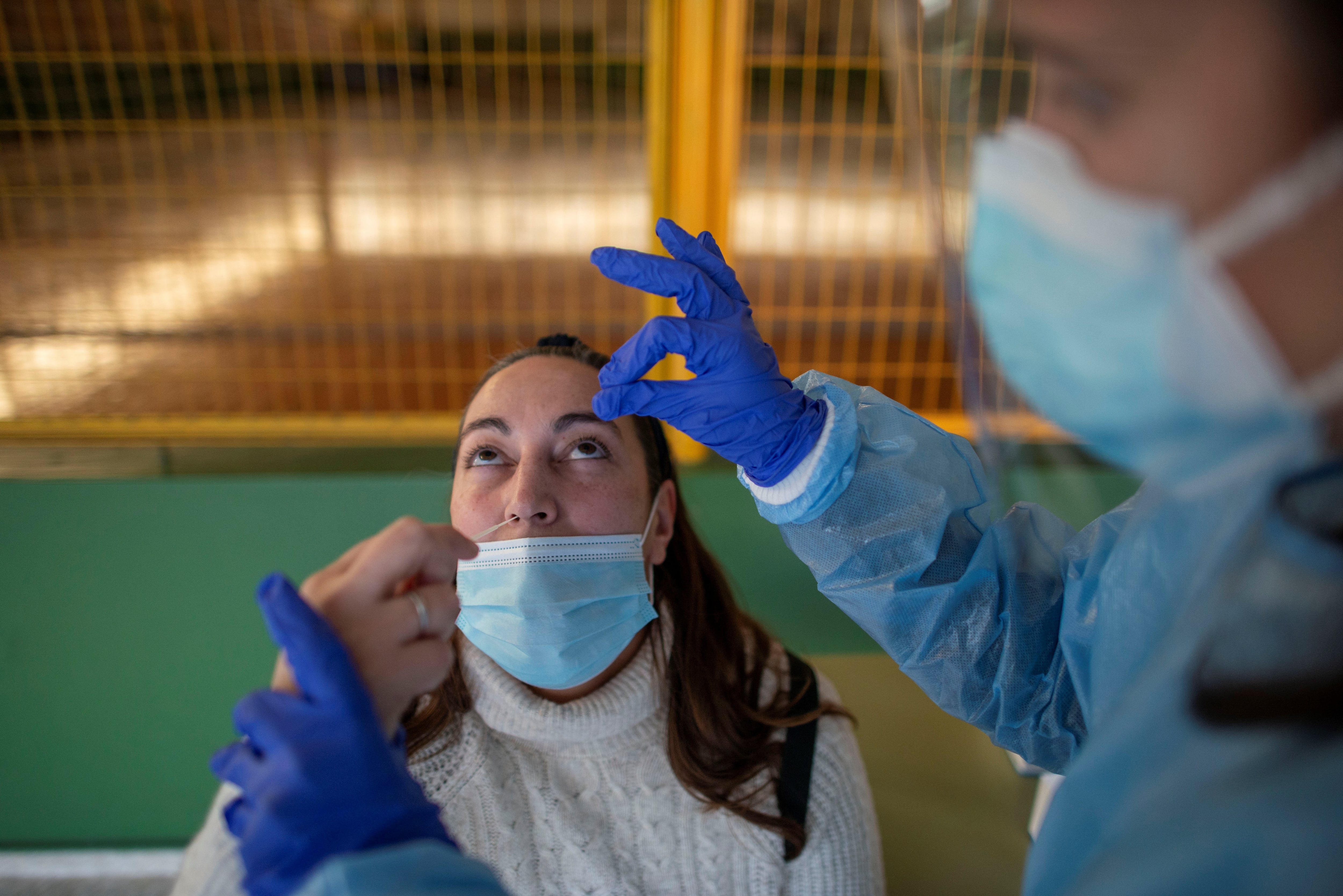 Un trabajador sanitario realiza un test de antígenos a una mujer durante el cribado poblacional.